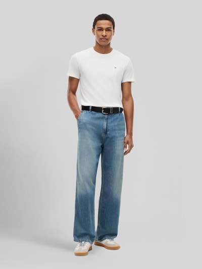 Męskamodel nosi Slim Fit T-Shirts aus reiner Baumwolle im 2er-Pack von Tommy Jeans, efekt: wielokolorowy, krój slim fit, wyhaftowane logo, okrągły dekolt, krótki rękaw, bawełna; zestaw 2 szt., Ganzkörperansicht von vorne.