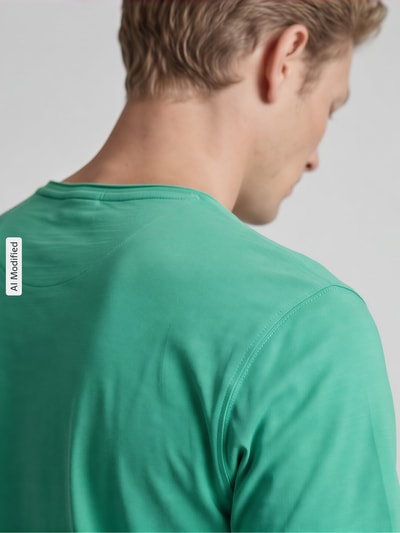 Männermodel trägt Regular Fit T-Shirt mit V-Ausschnitt von MCNEAL in Grün, reine Baumwolle, Rollsaum, Nahaufnahme Rückansicht.