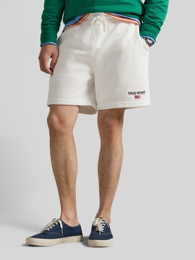 Männermodel trägt Regular Fit Sweatshorts aus Baumwoll-Mix von Polo Ralph Lauren, weiß, unifarben, Label-Schriftzug, Nahaufnahme Unterkörper.