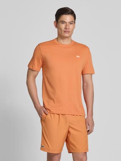 Männermodel trägt Regular Fit T-Shirt aus Baumwoll-Mix von Lacoste Sport in Unifarben mit Logo-Applikation, schnelltrocknend, Ganzkörperansicht von vorne