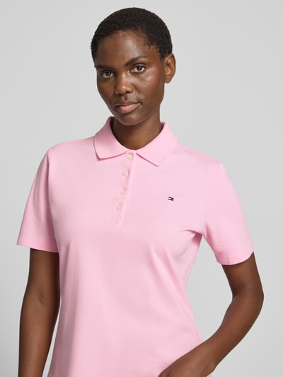 Frauenmodel trägt Regular Fit Poloshirts aus Baumwoll-Mix von Tommy Hilfiger in Rosa mit Logo-Stitching, Nahaufnahme Oberkörper.