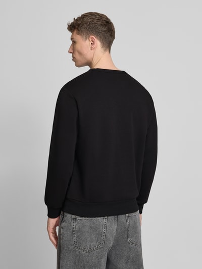 Männermodel trägt Sweatshirt mit Rundhalsausschnitt und Logo von GAP aus Baumwoll-Mix in Schwarz, Regular-Fit, Rückenlänge 69 cm, Ganzkörperansicht Rückansicht.