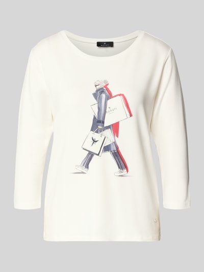Frauenmodel trägt Regular Fit Longsleeve aus Viskose-Mix mit Ziersteinbesatz von monari, Logo-Print, Motiv-Print, 7/8-Arm, Rundhalsausschnitt, cremefarben, Struktur glatt, Ganzkörperansicht von vorne.
