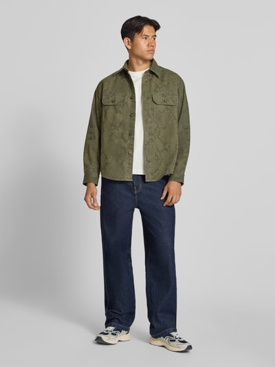 Männermodel trägt Oversized Freizeithemd aus reiner Baumwolle Modell 'Ebolt_1' von HUGO in Olivgrün, Herren Freizeithemd, Ganzkörperansicht von vorne.