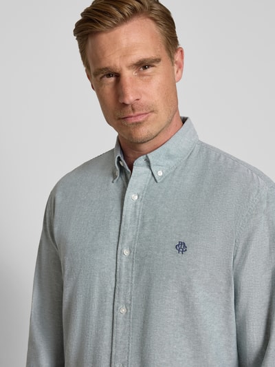 Męski model nosi Regular Fit Freizeithemd aus reiner Baumwolle von MCNEAL, Kołnierzyk typu button down, wyhaftowane logo, koszula casualowa, z długim rękawem, Ganzkörperansicht von vorne, długość tyłu w rozmiarze M: 76 cm, szerokość w rozmiarze M: 45 cm, długość rękawów w rozmiarze M: 66 cm.