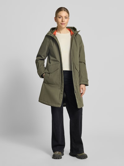Frauenmodel trägt Parka mit Kapuze und Pattentaschen von camel active in Olive, Relaxed Fit, Baumwoll-Mix, Ganzkörperansicht von vorne.