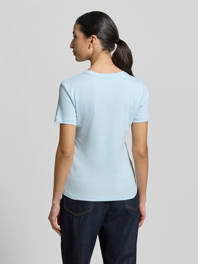 Frauenmodel trägt Slim Fit T-Shirt aus reiner Baumwolle von Tommy Hilfiger, Optik: Unifarben, Jersey, Kurzarm, Logo-Stitching, Ganzkörperansicht Rückansicht.