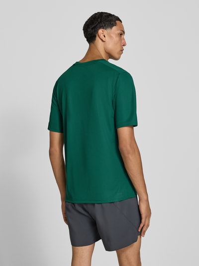 Männermodel trägt Regular Fit Sport-T-Shirt mit Logo-Print Modell 'WE BAS T' von adidas, dunkelgrün, adidas Training, Ganzkörperansicht Rückansicht.