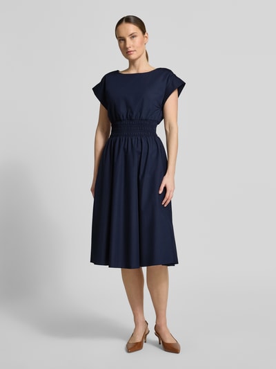 Frauenmodel trägt Knielanges Kleid mit Rundhalsausschnitt von Christian Berg Woman Selection, Material-Mix mit Baumwoll-Anteil, Taillierter Schnitt, Knielänge, Rundhalsausschnitt, Kappärmel, Elastisches Taillenband, Rückenlänge 110 cm, Brustweite 34 cm, einfarbig dunkelblau mit glatter Textur, Ganzkörperansicht von vorne.