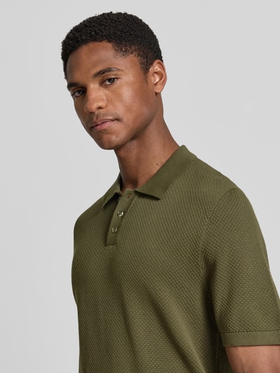 Męski model nosi Slim Fit Poloshirt mit kurzer Knopfleiste Modell 'TRITON' von Drykorn z bawełny, krój slim fit, zielony, z przodu, zbliżenie na górę ciała.