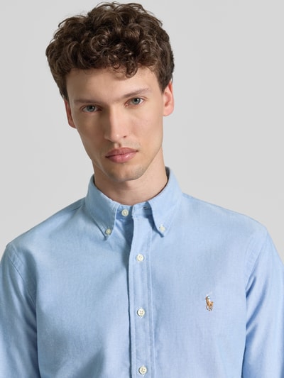 Mannmodel draagt Regular Fit Freizeithemd aus reiner Baumwolle van Polo Ralph Lauren in lichtblauw, oxford katoen, logo-stitching, button-down-kraag, doorlopende knoopsluiting, unicolor look, regular fit, detailopname bovenlichaam.