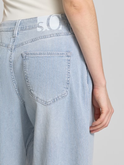 Frauenmodel trägt Barrel Leg Jeans aus Baumwoll-Mix von s.Oliver RED LABEL in hellblauem Denim mit 5-Pocket-Design, Nahaufnahme Rückansicht.