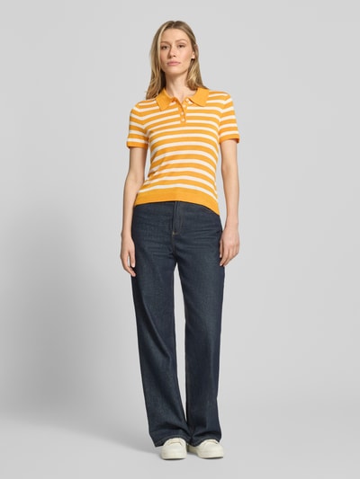 Frauenmodel trägt Regular Fit Poloshirt aus Lyocell-Seiden-Mix von Tommy Hilfiger, Optik:Allover-Muster, Feinstrick, Ganzkörperansicht von vorne.