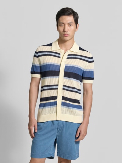 Mannenmodel draagt Slim Fit Poloshirt in tricotlook van Gant, puur katoen, polokraag, met korte mouwen, knoopsluiting, elastische boorden, ruglengte bij maat M 71 cm, kleuren crème, blauw, zwart en beige, vooraanzicht volledige lichaamsfoto