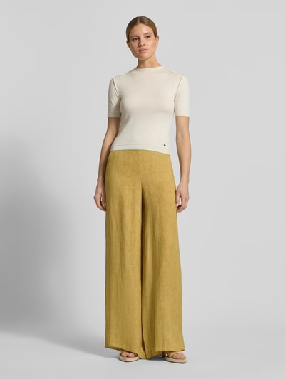 Kobiece modelka nosi Wide Fit Leinenhose mit Eingrifftaschen Modell 'LOTTELIA' von Marella z lnu, kolor musztardowy, wpuszczane kieszenie oraz zamek błyskawiczny, szerokość w rozmiarze 36: 37 cm, długość wewnętrzna nogawki w rozmiarze 36: 89 cm, widok całej sylwetki z przodu.