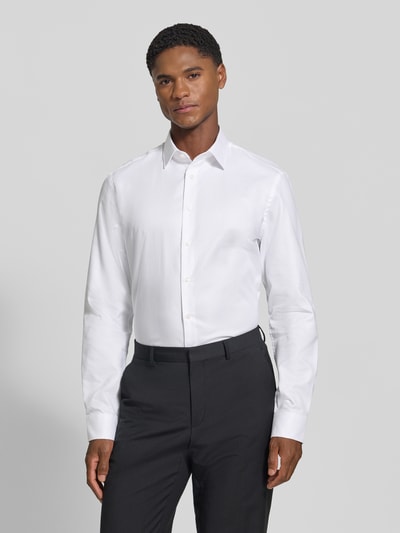 Männermodel trägt weißes Slim Fit Businesshemd aus reiner Baumwolle von Jake*s, glatte Textur, klassische Form, Ganzkörperansicht von vorne.