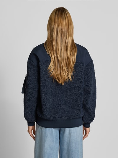 Frauenmodel trägt Teddyjacke mit Stehkragen Modell 'Emeline' von MOS MOSH in Dunkelblau, lockere Passform, Rückenansicht.