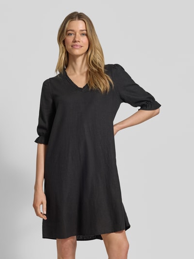 Frauenmodel trägt knielanges Damen Kleid aus Leinen-Viskose-Mix Modell 'FALAKKA' von B.Young, schwarze Farbe, gerader Schnitt, V-Ausschnitt, Rüschen, Rückenlänge 95 cm, Brustweite 38 cm, Ärmellänge 39 cm, Ganzkörperansicht von vorne.