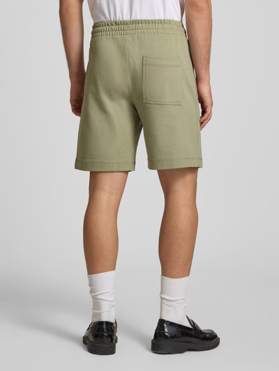 Männermodel trägt Shorts mit Label-Stitching Modell 'KARL' von Jack & Jones aus Baumwoll-Mix, Relaxed-Fit, Ganzkörperansicht Rückansicht.
