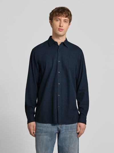 Męski model nosi Regular Fit Freizeithemd aus reiner Baumwolle von G-Star Raw, ciemnoniebieska koszula casualowa z kołnierzykiem typu kent, listwa guzikowa, wykonana z bawełny, szerokość w rozmiarze M: 45 cm, długość tyłu w rozmiarze M: 74 cm, długość rękawów w rozmiarze M: 67 cm, widok całej sylwetki z przodu.