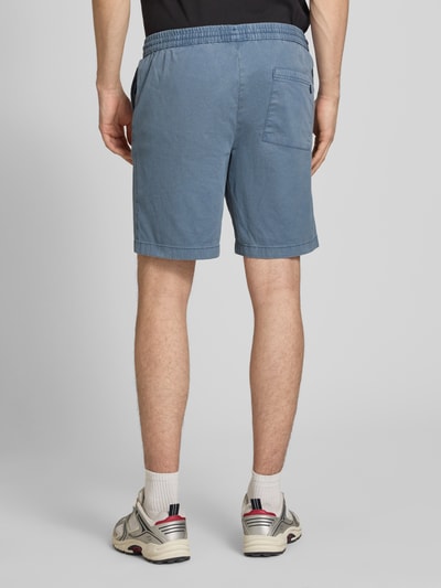 Männermodel trägt Shorts mit elastischem Bund Modell 'JAIDEN CARTER' von Jack & Jones aus Baumwoll-Elasthan-Mix, Strukturmuster, Regular-Fit, blaue Farbe, Ganzkörperansicht Rückansicht.