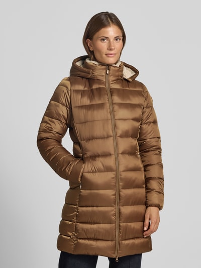 Frauenmodel trägt Steppmantel mit abnehmbarer Kapuze Modell 'CLELIA' von Save The Duck in glänzendem Braun, seitliche Taschen, Ganzkörperansicht von vorne.