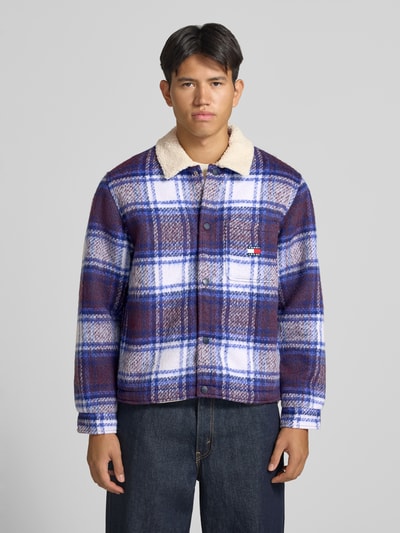 Männermodel trägt Oversized Hemdjacke mit Umlegekragen Modell 'TEDDY COLLAR BRUSHED' von Tommy Jeans, blau kariert, Ganzkörperansicht von vorne. Kontext: Herren Hemdjacke von Tommy Jeans