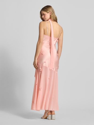 Frauenmodel trägt Maxikleid mit floralem Besatz von Gina Tricot in zartem Rosa mit Satin-Haptik, körpernahe Passform, Spaghetti-Träger, Rückenlänge bei Größe 36: 133 cm, Brustweite bei Größe 36: 34 cm, Ganzkörperansicht Rückansicht.