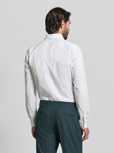 Männermodel trägt Slim Fit Businesshemd aus Baumwoll-Mix Modell 'HANK' von BOSS mit Allover-Streifenmuster, Ganzkörperansicht Rückansicht.