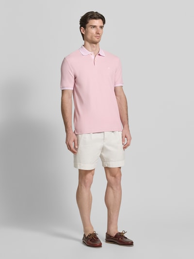 Männermodel trägt Modern Fit Poloshirt mit Stitching von Fynch-Hatton in Rosa, reine Baumwolle, Polokragen, Ganzkörperansicht von vorne.