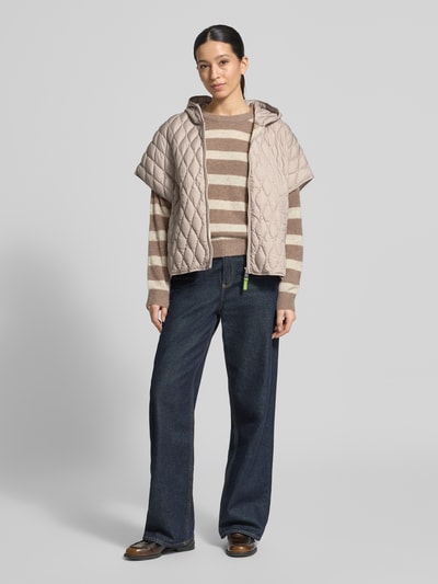 Frauenmodel trägt Steppjacke im kurzärmeligen Design von Fuchs Schmitt in Beige mit Kapuze, lockerem Schnitt und Reißverschluss, Ganzkörperansicht von vorne.