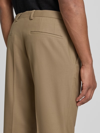 Männermodel trägt Super Slim Fit Anzughose aus Woll-Mix Modell 'Hesten253X' von HUGO in Beige, glatte Textur, Nahaufnahme Rückansicht, Herren Anzughose von HUGO.