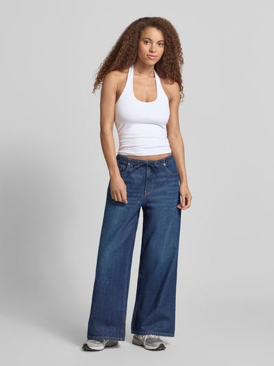 Frauenmodel trägt figurbetontes Neckholder-Top mit Rundhalsausschnitt von REVIEW im Baumwoll-Elasthan-Mix, Slim-Fit, Rückenlänge 32 cm, Ganzkörperansicht von vorne.