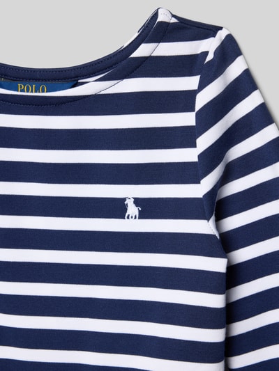 Mädchen trägt Minikleid mit Rundhalsausschnitt von Polo Ralph Lauren Teens, Material-Mix mit Viskose-Anteil, Nahaufnahme Oberkörper.