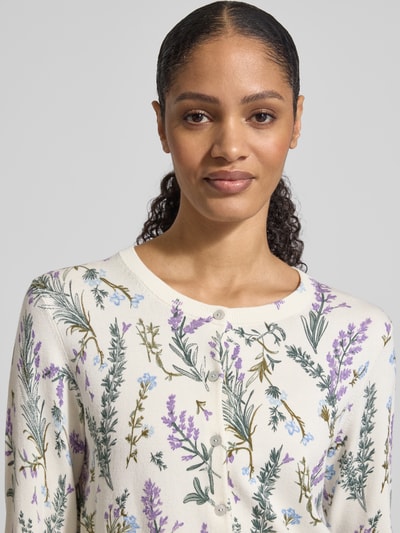 Frauenmodel trägt Strickcardigan aus Viskose-Mix von Christian Berg Woman mit floralem Muster, Rundhalsausschnitt, Knopfleiste, Nahaufnahme Oberkörper. Rückenlänge bei Größe S 53 cm, Ärmellänge 63 cm, Gerader Schnitt.