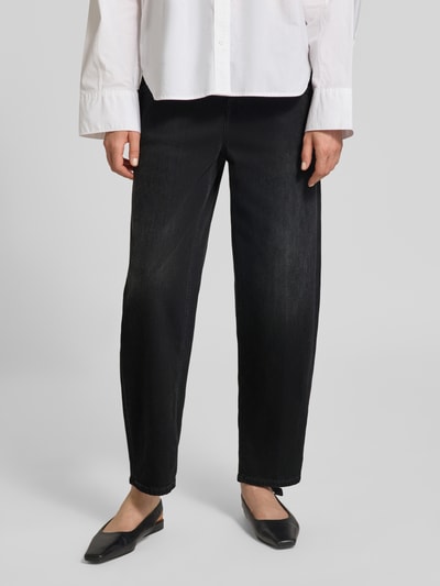 Frauenmodel trägt Barrel Fit Jeans mit Label-Detail Modell 'STOVER-X' von Closed, schwarze Baumwoll-Elasthan-Mix, Eingrifftaschen, Nahaufnahme Unterkörper, Kontext: Damen Jeans Barrel Fit mit Bundweite 40 cm, Innenbeinlänge 69 cm bei Größe 27/34.
