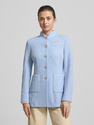 Kobiece model prezentuje Slim Fit Blazer mit Stehkragen und aufgesetzten Taschen od WHITE LABEL, mieszanka materiałów z dodatkiem wiskozy, krój slim fit, stójka, listwa guzikowa, nakładane kieszenie, długość tyłu w rozmiarze 36: 70 cm, szerokość w rozmiarze 36: 42 cm, długość rękawów w rozmiarze 36: 64 cm, jasnoniebieski kolor, faktura materiału wyczuwalna, widoczna prostota formy, całkowity widok z przodu.