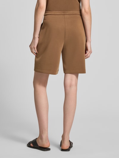 Frauenmodel trägt Top aus Modal-Mix mit Rundhalsausschnitt von Rich & Royal in Braun, Regular-Fit, Stretch-Anteil, Ganzkörperansicht Rückansicht.