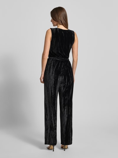 Frauenmodel trägt Regular Fit Jumpsuit aus Samt von Tom Tailor Denim in unifarbenem Schwarz mit breiten Trägern, Ganzkörperansicht Rückansicht.