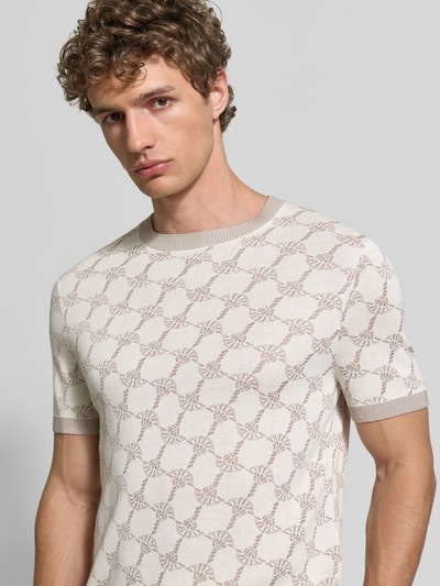 Männermodel trägt T-Shirt mit Viskose-Anteil und Rundhalsausschnitt Modell 'Ravao' von JOOP! Collection, Beige mit Muster, Nahaufnahme Oberkörper.