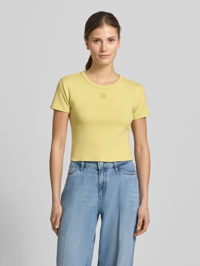 Frauenmodel trägt Slim Fit T-Shirt aus Baumwoll-Mix Modell 'DELANOR' von HUGO, Optik: Unifarben, Logo-Stitching, Cropped, Rundhals, Kurzarm, Stretch, Damen T-Shirt, Ganzkörperansicht von vorne.