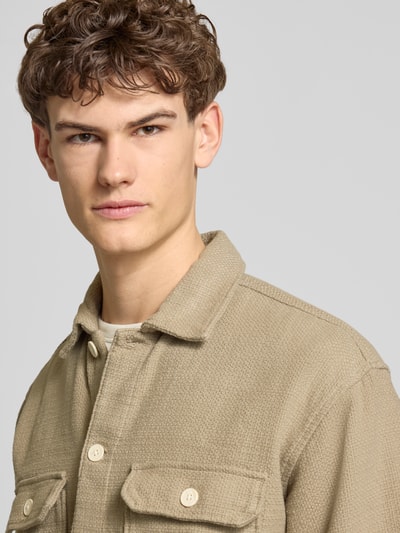 Männermodel trägt Regular Fit Hemdjacke mit Strukturmuster Modell 'Upstate' von Jack & Jones in Beige mit Brusttaschen, Nahaufnahme Oberkörper.
