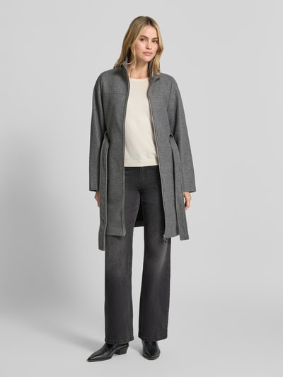 Frauenmodel trägt Regular Fit Mantel mit Taillengürtel von VERO MODA, in Grau, kombiniert mit heller Bluse, strukturierte Oberfläche, Ganzkörperansicht von vorne. Damen Teddy- / Webpelzmantel.