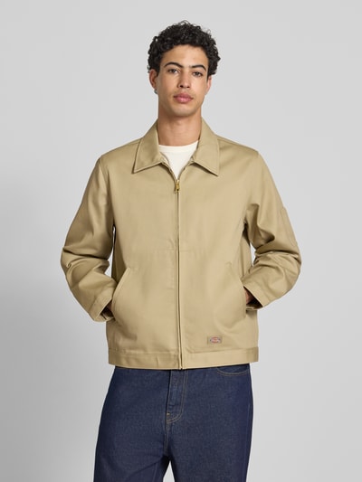 Männermodel trägt Jacke mit Reißverschluss Modell 'UNLINED EISENHOWER' von Dickies in Beige, Material-Mix, Regular-Fit, Eingrifftaschen, Label-Detail, Ganzkörperansicht von vorne. Kontext: Herren Jacke, Rückenlänge bei Größe M 67 cm, Schulterbreite 39 cm, Brustweite 53 cm, Ärmellänge 66 cm.