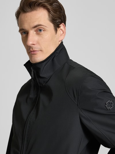 Męskimodel nosi Regular Fit Kurtka funkcyjna aus wasserdichtem Material Model 'LUCCA' von Strellson, efekt: jednolity kolor, stójka, długi rękaw, metalowa aplikacja z logo, kieszenie zapinane na zamek błyskawiczny, krój regular fit, materiał wodoodporny, wiatroszczelny, zamek błyskawiczny; zbliżenie na górną część ciała.