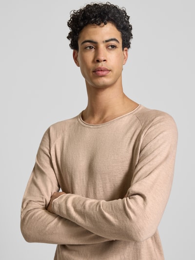 Mężczyzna nosi Bluzka z długim rękawem Regular Fit Longsleeve mit Logo-Patch model 'Breeze' od JACK & JONES z bawełny, imitacja dzianiny, okrągły dekolt, kolor beżowy, Nahaufnahme Oberkörper.