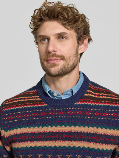 Männermodel trägt Slim Fit Strickpullover aus Baumwoll-Mix mit Rundhalsausschnitt von MCNEAL, farbenfrohes Muster, Nahaufnahme Oberkörper.
