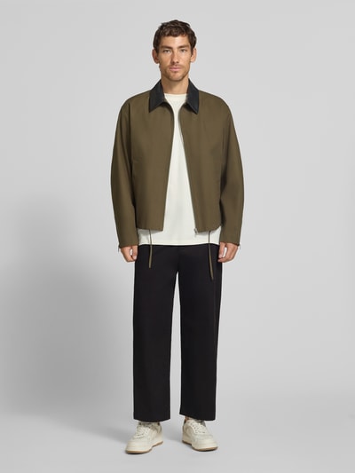 Männermodel trägt Loose Fit Weite Hose aus Baumwoll-Mix von Lacoste, schwarze Farbe, glatte Struktur, Ganzkörperansicht von vorne, Herren Weite Hose von Lacoste