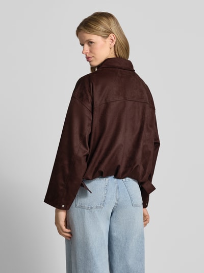 Frauenmodel trägt Jacke in Leder-Optik mit Reißverschluss und Eingrifftaschen von Gina Tricot in Braun, Material-Mix mit Stretch-Anteil, Relaxed-Fit, Ganzkörperansicht Rückansicht.