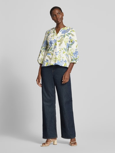 Frauenmodel trägt Bluse mit 3/4-Arm und Tunikakragen von ETERNA, weiß mit blau-grünem Blumenmuster, Loose Fit, Ganzkörperansicht von vorne.